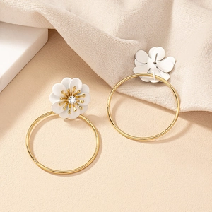 Detail of elegant white floral stud earrings with gold hoop and diamond center