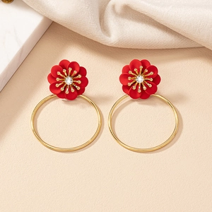 Detailed close-up of red floral earrings with gold hoop drops and crystal center decoration