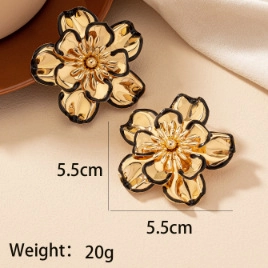 Detail shot of large floral earrings with black enamel accents and 5.5cm size scale