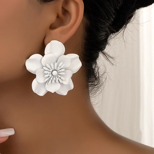 Close-up of elegant white oversized floral stud earrings with matte textured petals