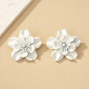 Detailed macro view of white matte flower earrings with 5-petal design and central stamens