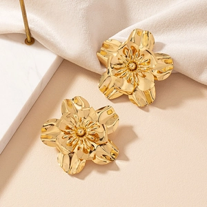 Macro shot of elegant golden blooming flower earrings with polished metallic petals