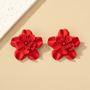 Close-up of red flower stud earrings with matte petals and detailed centers