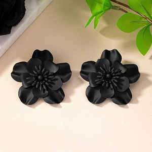 Macro shot of matte black multi-layered flower earrings with a textured finish