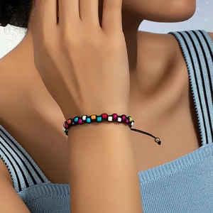 Close-up of bohemian colorful beaded bracelet with adjustable black woven cord on wrist