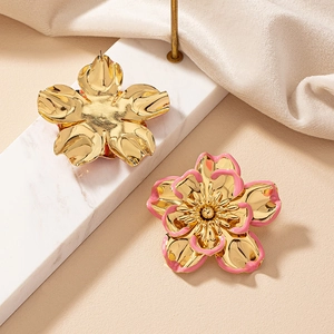 Detailed macro view of large pink enamel flower earrings with gold plated petal edges