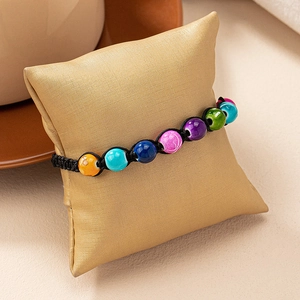 Detail of bohemian handmade beaded bracelet with colorful textured beads and woven cord