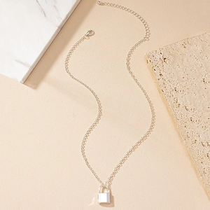 Minimalist silver chain necklace with a small lock pendant on elegant marble background