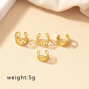 Detail of four-piece gold-plated ring set with wave, heart, and geometric patterns