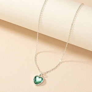 Minimalist silver necklace with an emerald green heart-shaped crystal pendant