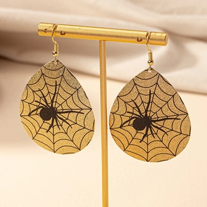 Close-up of gold teardrop earrings with spider web pattern on a jewelry display stand