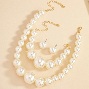 Flat lay of French vintage pearl jewelry set featuring necklaces and matching stud earrings