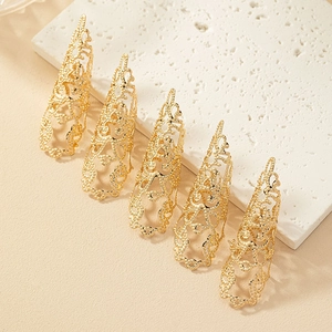 Lot de cinq bagues d'ongles dorées ajourées de style vintage palais sur une plaque en pierre