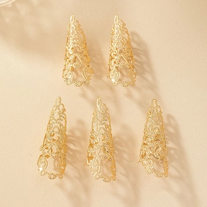 Détail de cinq bagues d'ongles dorées en métal ajouré style dentelle pour danse