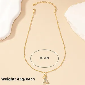 Detail of gold letter A pendant with crown and pavé diamonds on 38+7cm satellite chain