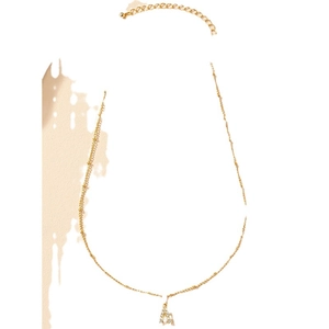 Elegante collana d'oro con pendente a lettera A con zirconi su uno sfondo minimalista