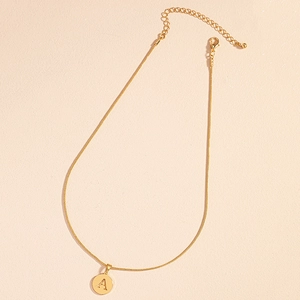 Detail view of golden letter A pendant on sleek snake chain with adjustable lobster clasp