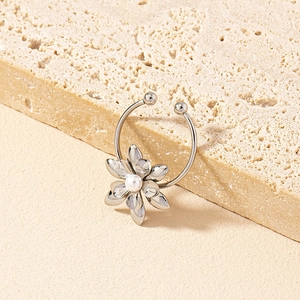 Elegante aro de nariz floral plateado con perla blanca sobre fondo de piedra natural