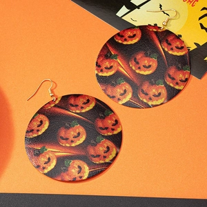 Dettaglio macro del motivo a zucca stampato su orecchini pendenti di Halloween
