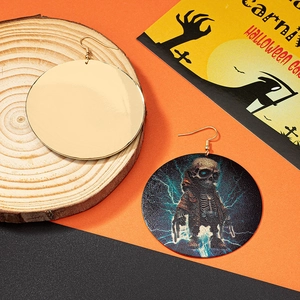Dettaglio di orecchini di Halloween con motivo a teschio e fulmine su sfondo arancione e nero