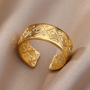 Gros plan d'une bague ouverte plaquée or 18k avec texture en losange sur soie