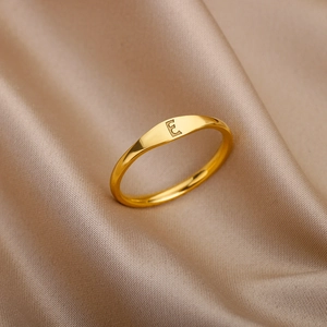 Elegant gold stainless steel ring featuring minimalist engraved letter E on silk background
