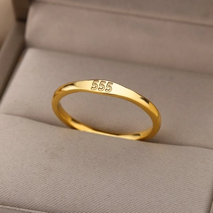 Macro shot of gold stainless steel ring with 555 numeric engraving on a jewelry box