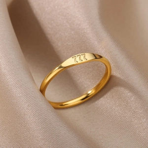 Detail of minimalist gold stainless steel ring featuring 222 angel number engraving