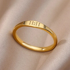 Macro detail of gold stainless steel 11:11 angel number ring on champagne silk background