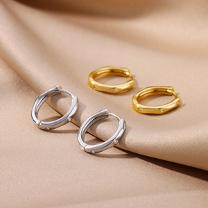 Elegant 18k gold and silver plated hoop earrings with sparkling zircon on silk background
