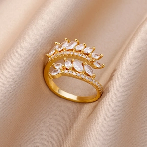 Close-up of golden marquise-cut zircon ring with elegant leaf design on champagne silk
