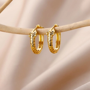Detail of 18k gold plated giraffe pattern hoop earrings with zircons on silk fabric