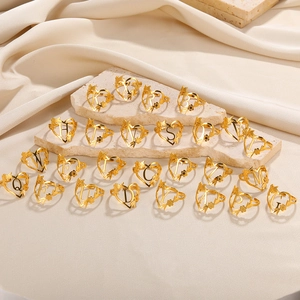 Detail von goldenen 18k Edelstahl-Herzringen mit Initialen und floralen Akzenten