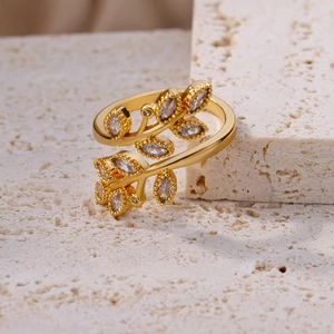 Detailed macro view of golden leaf branch ring featuring marquise-cut zircon stones