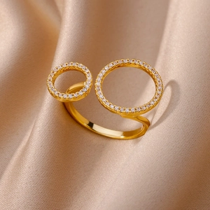 Detailed view of layered golden open ring featuring zircon pave on dual circle bands