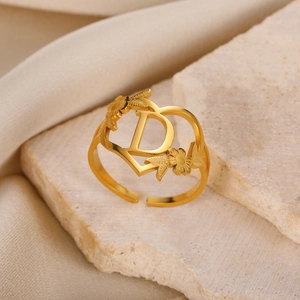Nahaufnahme der goldenen Herzring mit Buchstabe D und Blumen auf hellem Stein