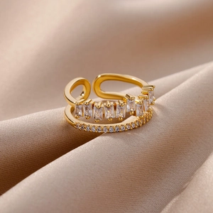 Detail of adjustable gold ring with double-layered cubic zirconia and silk background
