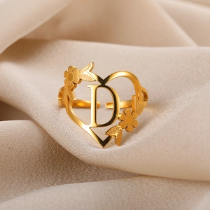 Detail eines verstellbaren Goldrings in Herzform mit Buchstabe D und Blumen