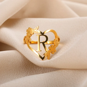 Detail eines verstellbaren Rings mit Herzform und dem Buchstaben R in 18k Goldoptik