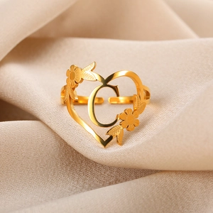 Detail eines vergoldeten 18k Edelstahl Herzrings mit Blumenakzenten und dem Buchstaben C