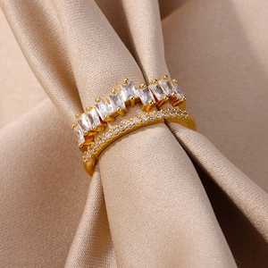 Detailed close-up of double-layer gold ring with baguette and round cubic zirconia stones