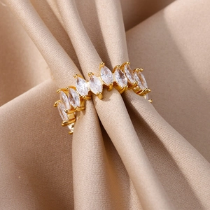 Macro shot of gold-plated marquise-cut cubic zirconia ring on champagne silk fabric