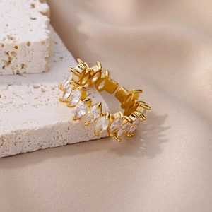 Detail of gold-plated copper ring with marquise-cut zircons on elegant white stone
