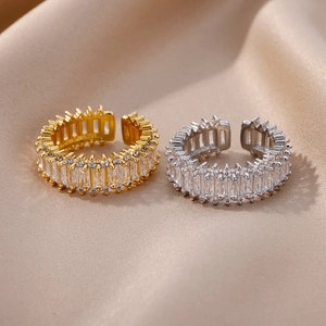 Detail of adjustable gold and silver rings with rectangular zircon stones on silk fabric
