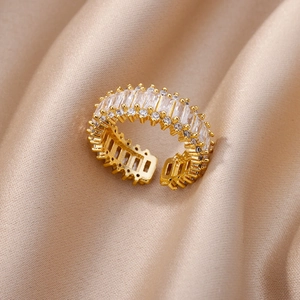 Detailed close-up of double-row gold ring with cubic zirconia on champagne silk fabric