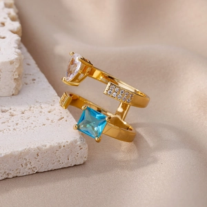 Macro detail of a geometric gold double-layer ring with blue and clear zircon stones