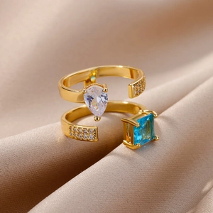 Detail of double-layer gold ring with pear-cut white and square-cut blue zircon stones