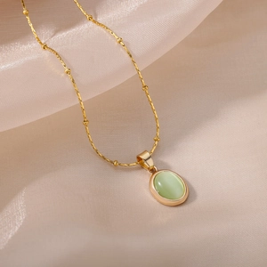 Elegant gold titanium steel necklace featuring a light green oval cat-eye stone pendant