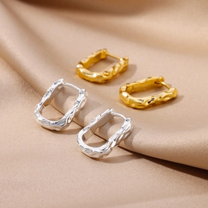 Irregular lava style earrings in 18k gold and silver finishes on satin fabric