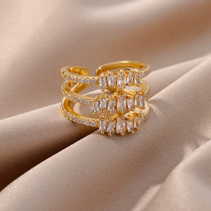 Detail of three-layer gold ring with rectangular and round zirconia on champagne silk